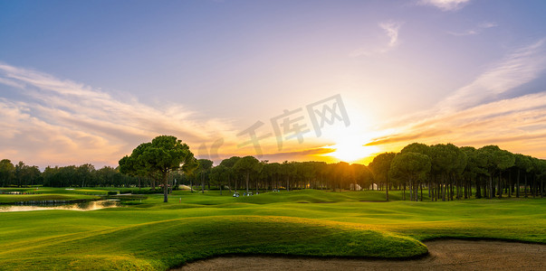 高尔夫摄影照片_高尔夫球场在日落时与美丽的天空和沙坑。