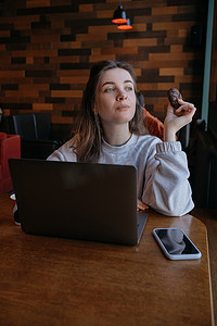 咖啡馆摄影照片_自由职业女性很高兴在远程咖啡馆工作