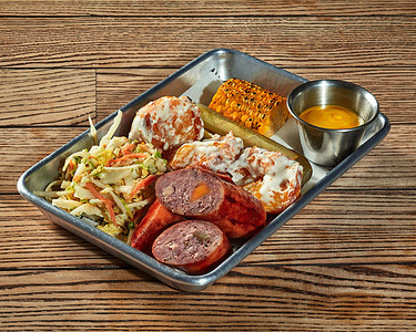 胡萝卜土豆摄影照片_午餐套餐包括香肠、土豆炸丸子配奶油酱、蔬菜沙拉、泡菜和烤玉米