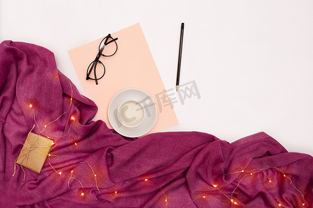 一杯咖啡，黑眼镜，粉红色的纸，上面写着新年目标。