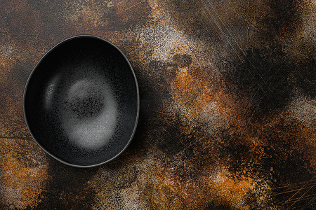 黑陶碗，有文字或食物的复制空间，有文字或食物的复制空间，顶视图平躺，在旧的深色乡村餐桌背景上