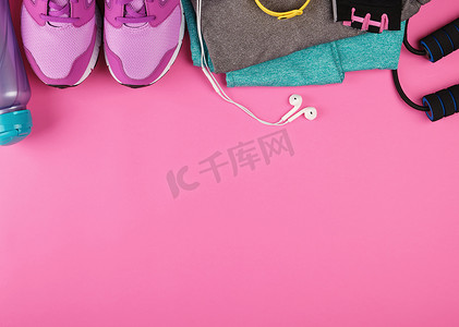 粉色女式运动鞋、一瓶水、手套和跳绳