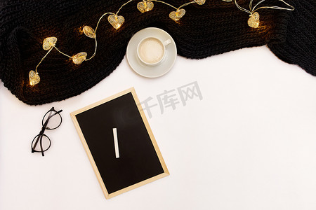 目装饰摄影照片_一杯咖啡、一块黑色小木板和一支写有新年目标的白色粉笔。