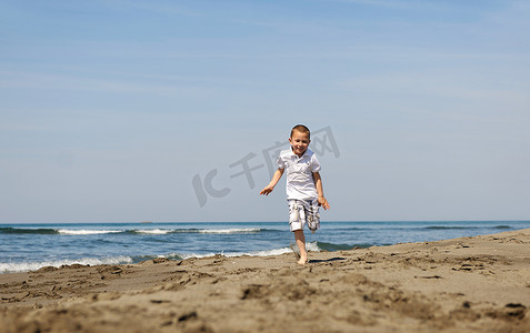 在海滩上奔跑的小男孩