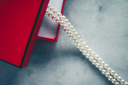 红色礼盒中的精美珍珠、奢华礼物 — 珠宝和她风格概念的奢华礼物