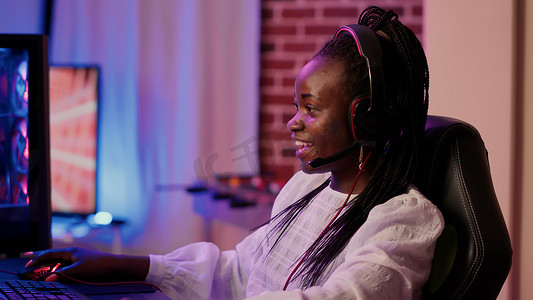 游戏直播摄影照片_非洲裔美国游戏玩家女孩使用游戏键盘进行直播的手持镜头