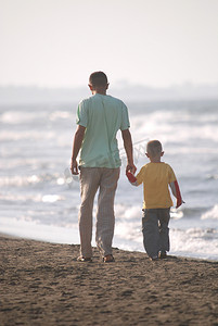 父亲和儿子在沙滩上散步