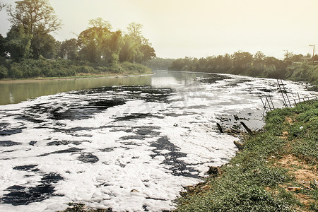背景河流摄影照片_由于工业在排水前未对水进行处理，导致河流水污染。