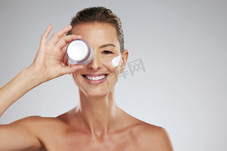 奶油、眼部护肤品和成熟女性，在灰色模型工作室背景下使用天然健康美容产品。