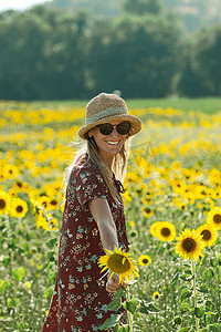 午后阳光摄影照片_向日葵丛中的女人享受着美丽的午后阳光。