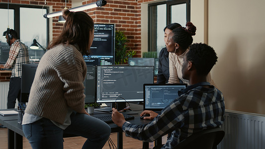 编程的字体摄影照片_软件开发人员讨论编程，而团队的其他成员加入讨论