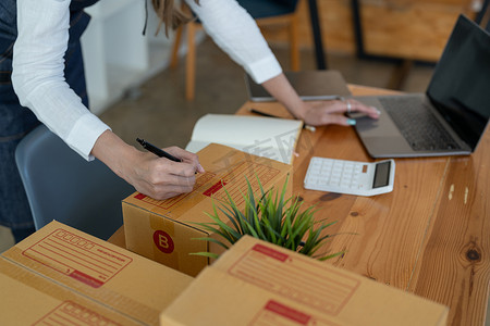 启动小企业企业家中小企业在盒子上写地址。企业主在家办公，在线营销包装和交付，适合中小企业概念。