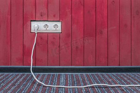 将电源和能量插头电缆连接到红色木墙表面的插座