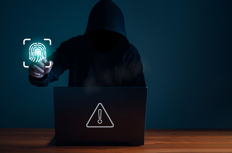 黑客在黑暗中使用笔记本电脑工作。 