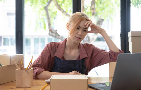 一幅年轻严肃的亚洲女性的肖像,在办公室里用笔记本