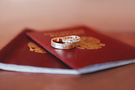 结婚金色摄影照片_护照上镶有钻石的结婚金戒指。
