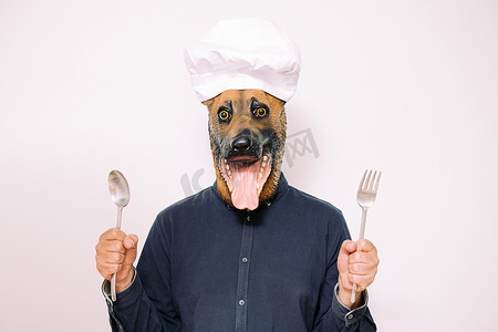 戴狗面具的厨师展示了吃的勺子和叉子