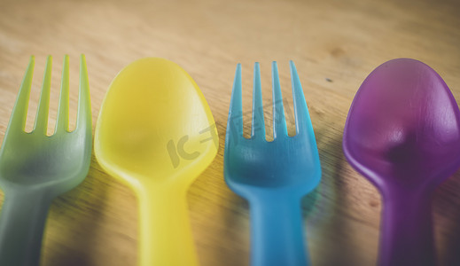 塑料叉子摄影照片_多彩多姿的塑料叉子和勺子。环境概念。