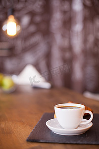 背景模糊的黑石板上一杯咖啡的简约组合