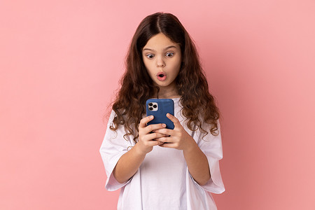 小女孩使用手机在社交网络上阅读令人震惊的帖子，感到震惊。