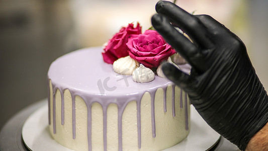 生日快乐蛋糕摄影照片_设计师用标志装饰磨砂丁香浪漫生日快乐蛋糕顶部