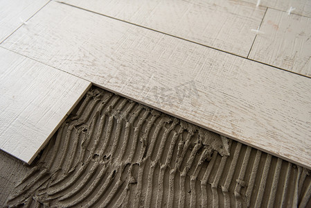 地板铺摄影照片_陶瓷木纹瓷砖和地板铺砖工具