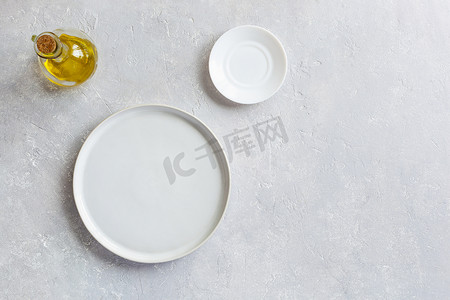白色空盘子、小盘子和橄榄油罐，顶视图