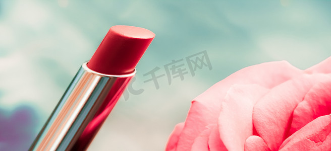 液体背景中的粉色口红和玫瑰花、防水魅力化妆品和唇彩化妆品产品，适用于豪华美容品牌假日设计