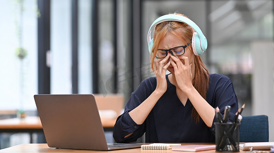 过度劳累的年轻女性上班族在长时间使用笔记本电脑后出现视力模糊症状，感到眼睛疲劳紧张问题