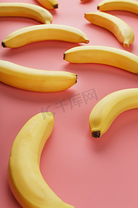 粉红色背景上香蕉的几何图案。