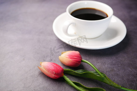 咖啡，黑色背景上的郁金香花。