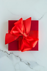 红色节日礼物盒摄影照片_大理石上的豪华红色节日礼物