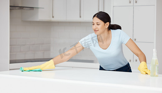 妇女用家政喷雾瓶产品擦拭或清洁厨房柜台，用于家庭清洁服务、女佣或工人。