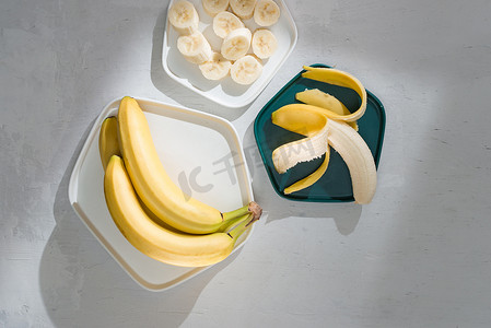 美味的香蕉和带切片的木制背景碗