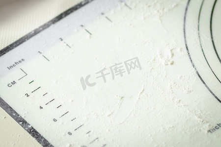 白色硅胶烹饪垫，上面有厘米和英寸标记，上面撒有面粉，复制空间