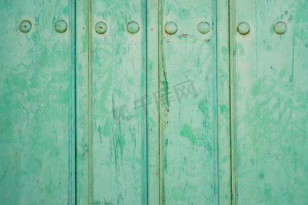 破旧的绿色彩绘木门和铁钉