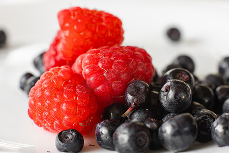 许多多汁的新鲜成熟红树莓浆果与黑莓隔离在白色背景