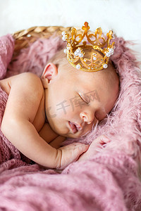 女孩皇冠摄影照片_戴着女孩皇冠的新生婴儿。