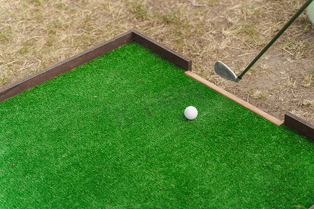 高尔夫运动游戏与尼布利克和白球在绿草上。