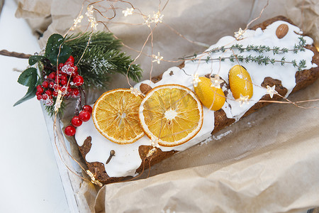 传统的圣诞纸杯蛋糕，饰有干橙角、丁香香料和迷迭香小枝，用牛皮纸装饰