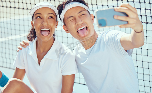 网球队用手机拍搞笑的自拍，滑稽的体育人在球场上疯狂训练体育比赛，在健身活动中合作。