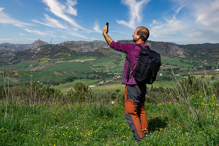 手机网络信号摄影照片_男子在山里寻找手机信号覆盖