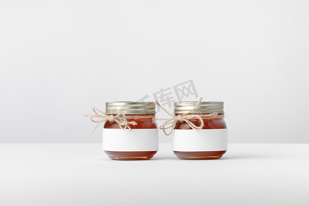 两个罐子，配有蜂蜜、麻线和白色标签