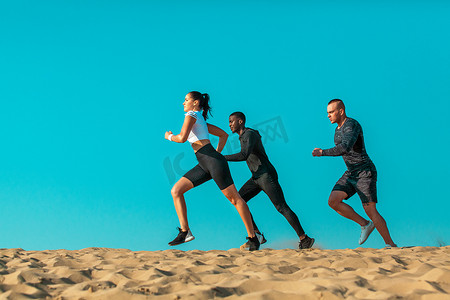 一群年轻的男女运动员，适合在天空背景下奔跑的运动员。