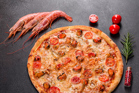 混凝土背景下美味的切片披萨，配有海鲜和番茄