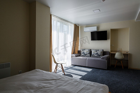 酒店房间内的大灰色沙发配有电视和大窗户