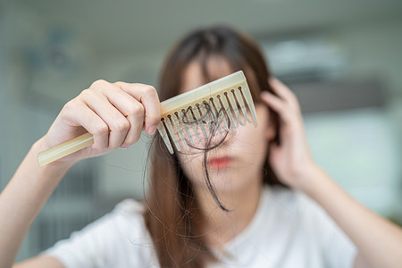 亚洲女性在梳子刷上有长脱发的问题。
