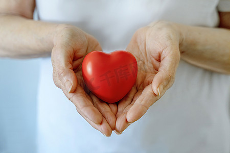 祖母手捧红心、医疗保健、爱、器官捐赠、正念、幸福、家庭保险和 CSR 概念、世界心脏日、世界卫生日、国家器官捐赠日