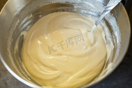 赶车鞭子摄影照片_在食品加工机中打发甜点的奶油。