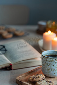 在舒适的冬日夜晚，用蜡烛、茶和饼干读书。